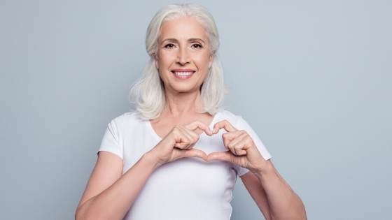 Woman making a heart with her hands for American Heart Month