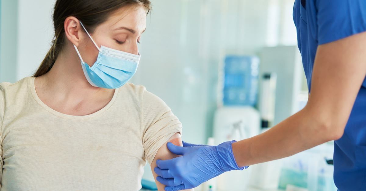 female doctor puts patch on patient's arm